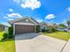 Gray house with brown garage door and landscaping at 14308 Edinburgh Moor Dr, Wimauma, FL 33598