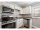 Updated kitchen boasts stainless steel appliances, white cabinetry, and granite countertops at 2558 12Th S Ave, St Petersburg, FL 33712