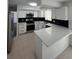 Modern kitchen boasts white cabinets, black backsplash, and stainless steel appliances, complemented by white countertops at 5770 46Th N Ave, Kenneth City, FL 33709
