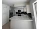 Bright, updated kitchen featuring white shaker cabinets, sleek black backsplash, and stainless steel appliances at 5770 46Th N Ave, Kenneth City, FL 33709