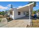 Covered carport and side view of a white house with teal accents and landscaping at 753 37Th S Ave, St Petersburg, FL 33705