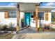 Teal front door with wood accents, flanked by windows and shutters at 753 37Th S Ave, St Petersburg, FL 33705