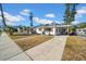 Inviting home with teal front door, wooden shutters, and a spacious driveway at 753 37Th S Ave, St Petersburg, FL 33705