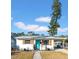 Charming white home with teal door, wooden shutters, and covered carport at 753 37Th S Ave, St Petersburg, FL 33705