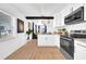 Open-concept kitchen with white cabinets, stainless steel appliances, and wood-look flooring at 753 37Th S Ave, St Petersburg, FL 33705