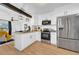 Updated kitchen featuring white shaker cabinets, stainless steel appliances, and wood-style flooring at 753 37Th S Ave, St Petersburg, FL 33705