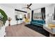 Modern living room with teal sofa, wood floors, and a glimpse of the kitchen at 753 37Th S Ave, St Petersburg, FL 33705