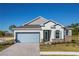 Single-story home featuring a light blue garage door, stone accents, and a landscaped front yard at 25539 Calusa Dr, Punta Gorda, FL 33955