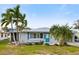 Front exterior view of a single-story home with teal shutters, palm trees, and landscaping at 4532 103Rd W St, Bradenton, FL 34210