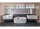 Modern bathroom featuring dual vanities, a soaking tub, and dark tile flooring at 1046 Snell Isle Ne Blvd, St Petersburg, FL 33704