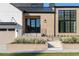 The home's entrance features a sleek glass door, black metal railing, and landscaped planters at 1046 Snell Isle Ne Blvd, St Petersburg, FL 33704