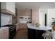 Modern kitchen featuring wood cabinets, black island, and stainless steel appliances at 1046 Snell Isle Ne Blvd, St Petersburg, FL 33704