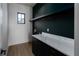 Modern laundry room with black cabinets, marble countertop, and wood-look flooring at 1046 Snell Isle Ne Blvd, St Petersburg, FL 33704