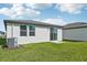 Back exterior of a home with a grassy yard, AC unit, and sliding glass door at 14049 Crutchfield Ct, Parrish, FL 34219