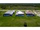 Aerial view showcases three homes with screened-in pools and lush green lawns at 243 Rotonda S Blvd, Rotonda West, FL 33947