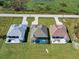 An elevated perspective showcasing three similar homes with pools in a residential area at 243 Rotonda S Blvd, Rotonda West, FL 33947