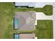 Aerial view of the house showcasing the roof, screened-in pool, and brick driveway at 243 Rotonda S Blvd, Rotonda West, FL 33947