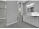Modern bathroom with white vanity, gray tile, and walk-in shower at 243 Rotonda S Blvd, Rotonda West, FL 33947