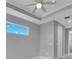 Bright bedroom with tray ceiling, ceiling fan, and large window at 243 Rotonda S Blvd, Rotonda West, FL 33947