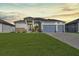 Modern two-story home with a three-car garage and lush green lawn at 243 Rotonda S Blvd, Rotonda West, FL 33947