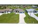 Well-manicured lawn with a brick driveway leading to a modern home with a three-car garage at 243 Rotonda S Blvd, Rotonda West, FL 33947