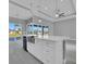 Bright, open kitchen with island, stainless steel farmhouse sink, and sliding glass doors at 243 Rotonda S Blvd, Rotonda West, FL 33947