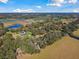 Aerial view of a house situated on a sprawling property with trees and fields at 2707 De Montmollin Rd, Plant City, FL 33565