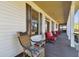 Inviting front porch with wicker rocking chair and red seating at 2707 De Montmollin Rd, Plant City, FL 33565