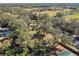 Aerial view of a property with trees, buildings, and a pond at 2707 De Montmollin Rd, Plant City, FL 33565