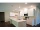 Modern kitchen equipped with stainless steel appliances, white cabinets, and an island with sink at 2550 Mauritania Rd, Punta Gorda, FL 33983