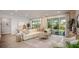 Living room with plush sofa, wood floors, area rug, sliding glass doors, and natural light at 2550 Mauritania Rd, Punta Gorda, FL 33983