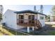 Exterior view of home with wooden deck, white siding, and dark trim at 809 59Th Ave, St Pete Beach, FL 33706