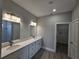Modern bathroom featuring dual vanities, large mirror, and tile flooring at 1262 Oxsalida St, Port Charlotte, FL 33952