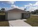 Front exterior of a single-story home with a one-car garage, driveway, and landscaping at 1262 Oxsalida St, Port Charlotte, FL 33952