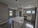 Kitchen with island, white cabinets, stainless steel appliances, pendant lighting, and tile flooring at 1262 Oxsalida St, Port Charlotte, FL 33952