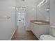 Bathroom with vanity, sink, and toilet; view into adjacent room with wood-style flooring at 2061 Willow Hammock Cir # 107, Punta Gorda, FL 33983