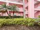 Pink apartment building exterior with tropical landscaping at 2061 Willow Hammock Cir # 107, Punta Gorda, FL 33983