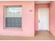 Pink exterior wall with white front door and window at 2061 Willow Hammock Cir # 107, Punta Gorda, FL 33983