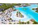 Community crystal lagoon with sandy beaches, lounge chairs, and inflatable water park at 9201 Sanders Tree Loop, Wesley Chapel, FL 33545