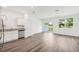 Bright, open kitchen featuring white shaker cabinets, stainless steel appliances, and wood-look flooring at 4280 Banjo Lake Rd, Land O Lakes, FL 34639