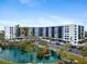 Beautiful waterfront condo building with lush landscaping and palm trees at 5855 Midnight Pass Rd # 108, Sarasota, FL 34242