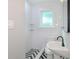 Bright bathroom with white subway tile, black fixtures, and a patterned floor at 603 W Emma St, Tampa, FL 33603