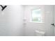 White tiled bathroom with shower, toilet and window at 603 W Emma St, Tampa, FL 33603