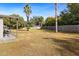 Large backyard with a clothesline, palm trees, and wooden fence at 4920 Sedeno Dr, Zephyrhills, FL 33541