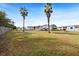 Spacious backyard with palm trees and a wooden fence at 4920 Sedeno Dr, Zephyrhills, FL 33541