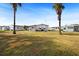 Rear view of home with grassy backyard and neighboring homes at 4920 Sedeno Dr, Zephyrhills, FL 33541