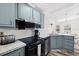 Kitchen boasts black appliances, gray cabinets, and a light, airy feel at 4920 Sedeno Dr, Zephyrhills, FL 33541