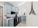 View of the kitchen's black appliances, gray cabinets, and decorative wall art at 4920 Sedeno Dr, Zephyrhills, FL 33541