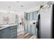 Kitchen with gray cabinetry, stainless steel appliances, and an adjacent dining area at 4920 Sedeno Dr, Zephyrhills, FL 33541