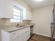 White kitchen cabinets, granite countertops, and stainless steel dishwasher at 4110 E Comanche Ave, Tampa, FL 33610